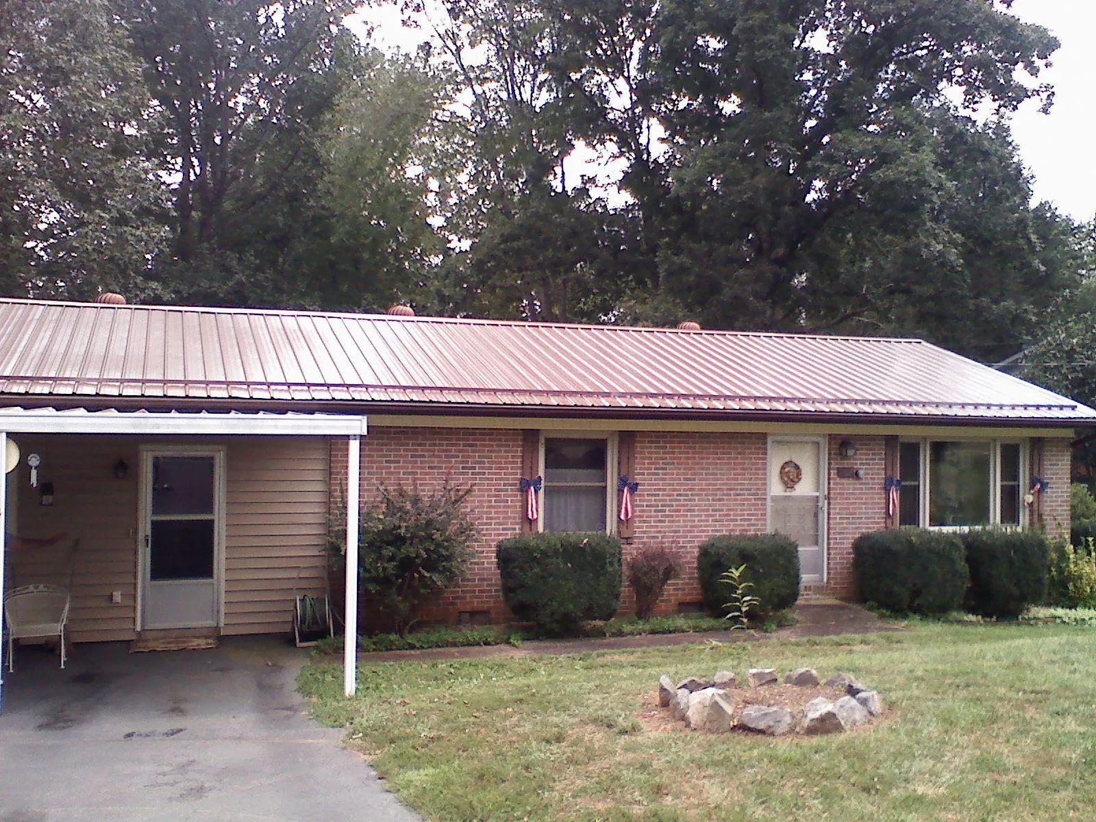 Bronze metal roof and carport on a brick ranch home — Roof Repair work by our crew in Luck