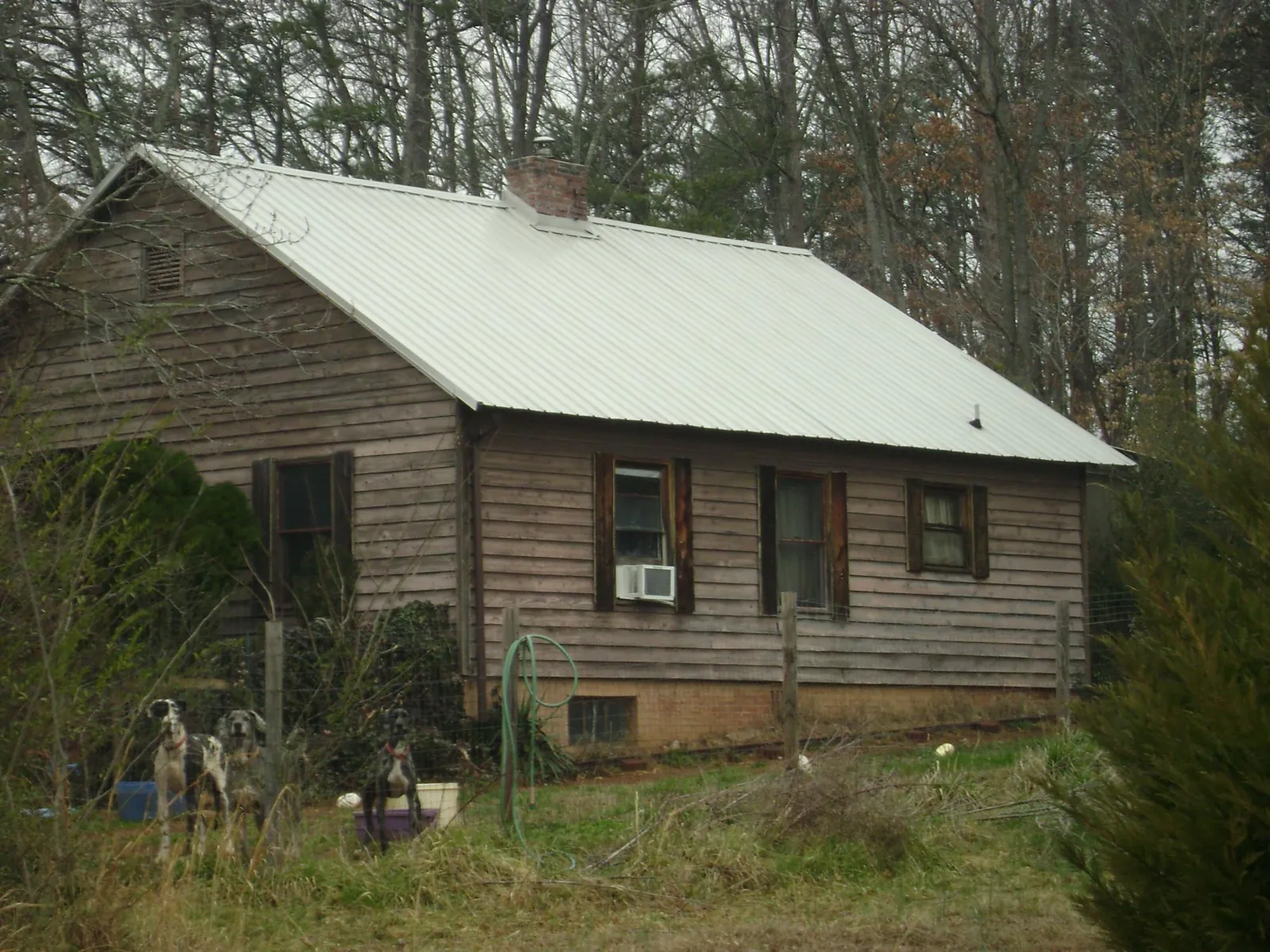 White metal roof on an old wood sided farmhouse, from a Metal Roof Installation job in Luck
